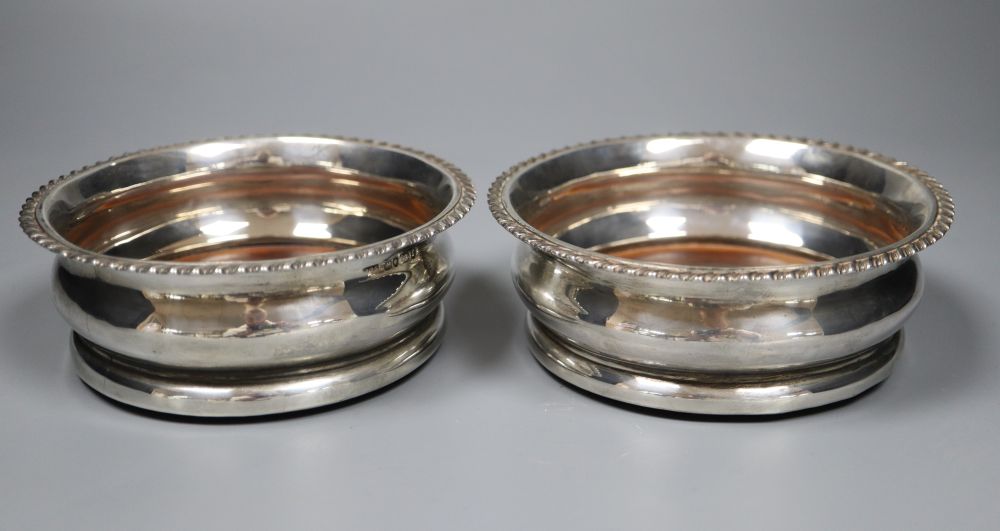 A pair of George IV silver wine coasters with tuned wooden bases, Adey Bellamy Savory, London, 1827, 13.3cm.